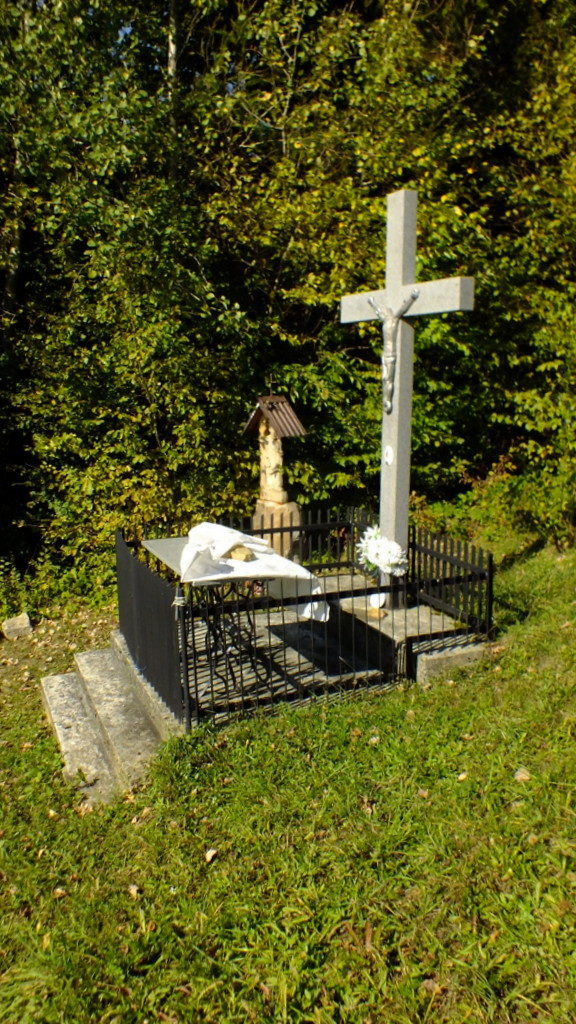 Krzyż i figurka św Wojciecha nad źródłem.